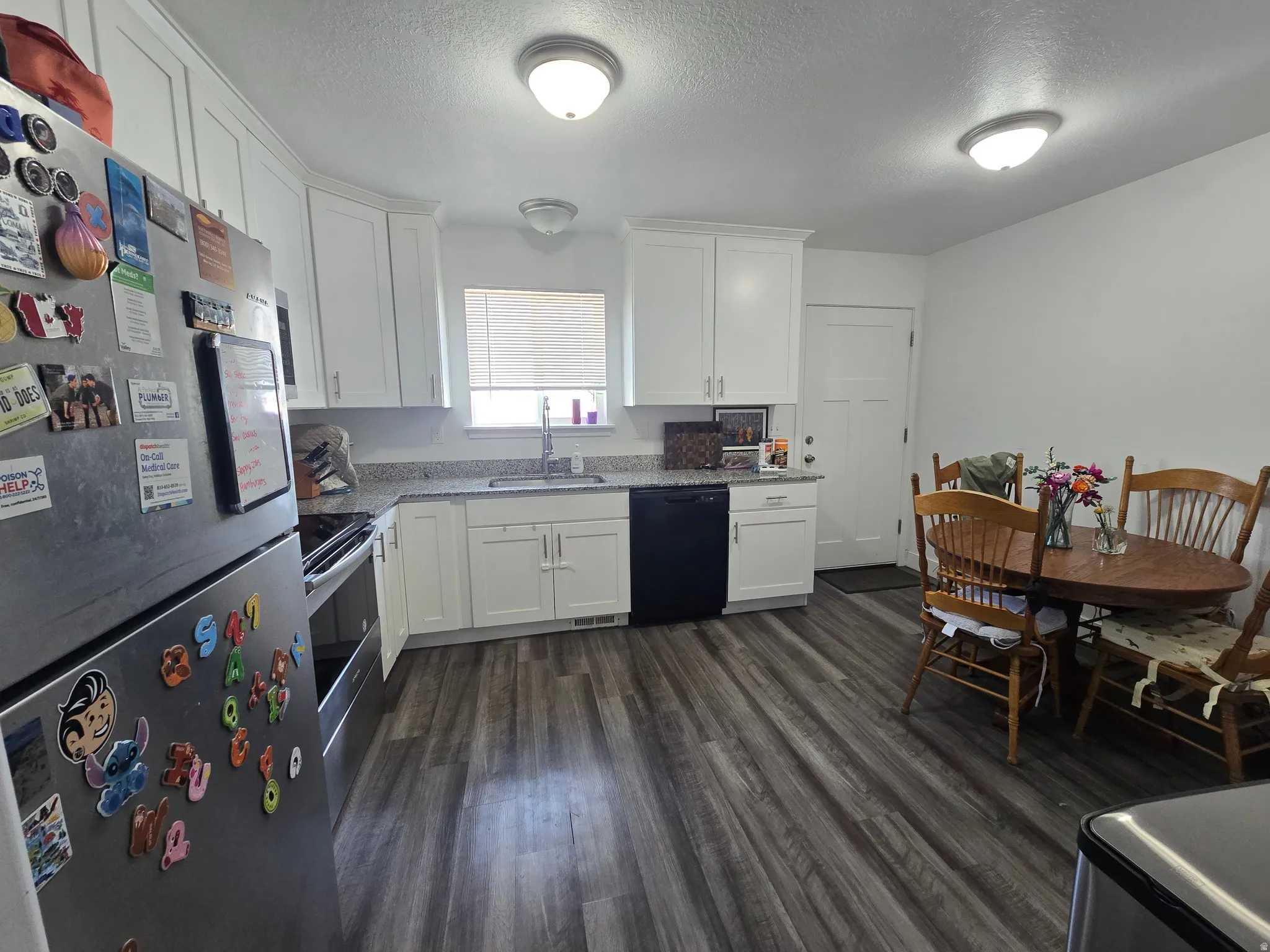 Kitchen featuring white cabinetry, light-toned countertops, and wood-finish flooring