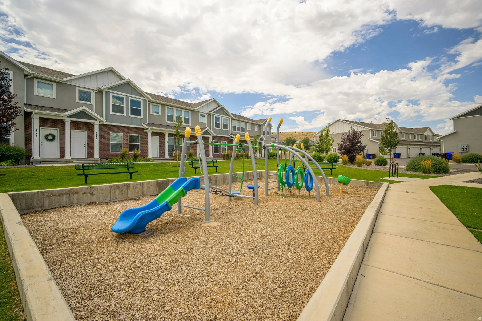 Central playground area with rubber mulch surfacing and a blue and green slide