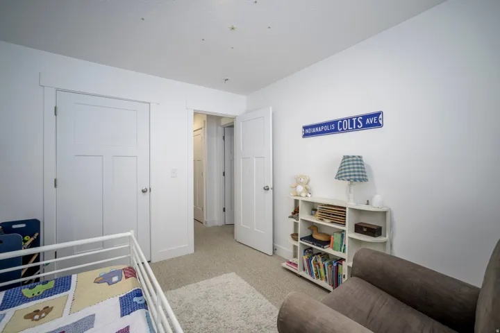 Carpeted room featuring white walls, white trim, and two white panel doors
