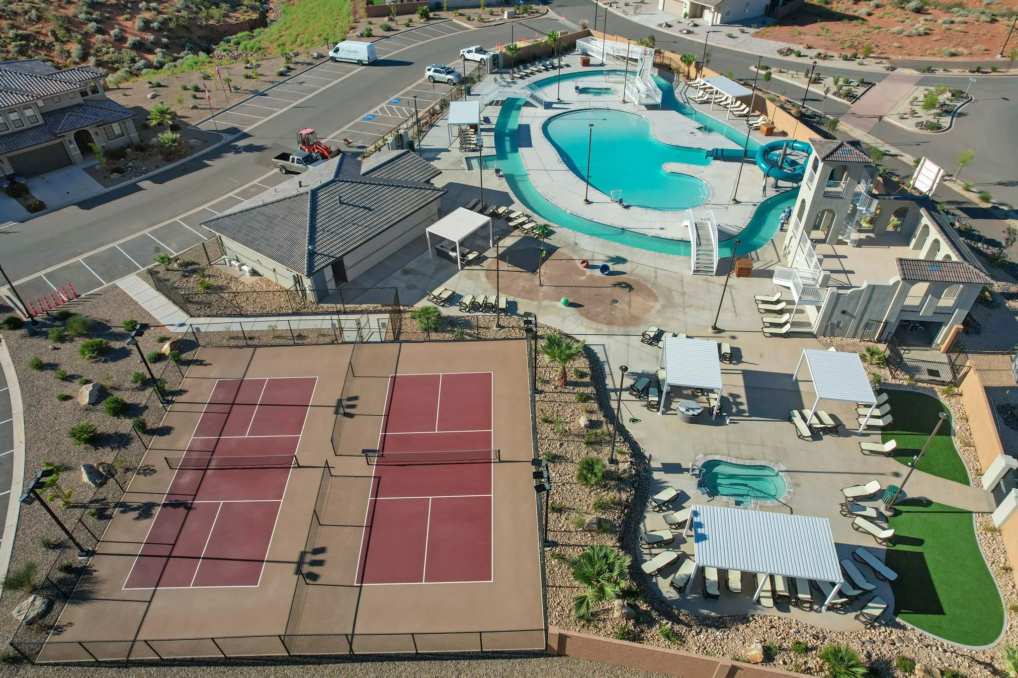 Community amenities featuring multiple swimming pools, a water slide, shaded lounging areas, and dual pickleball courts