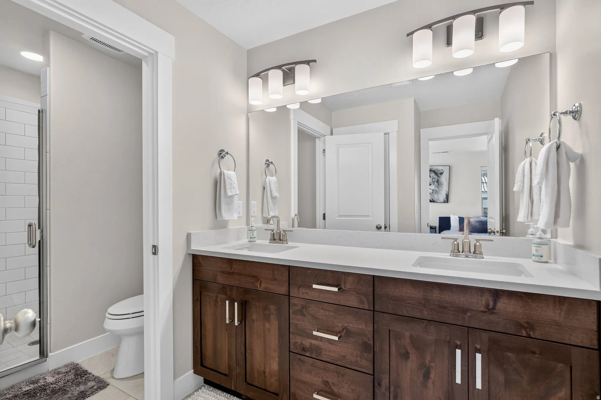 Double vanity with integrated sinks, white countertops, and dark wood-finish cabinetry