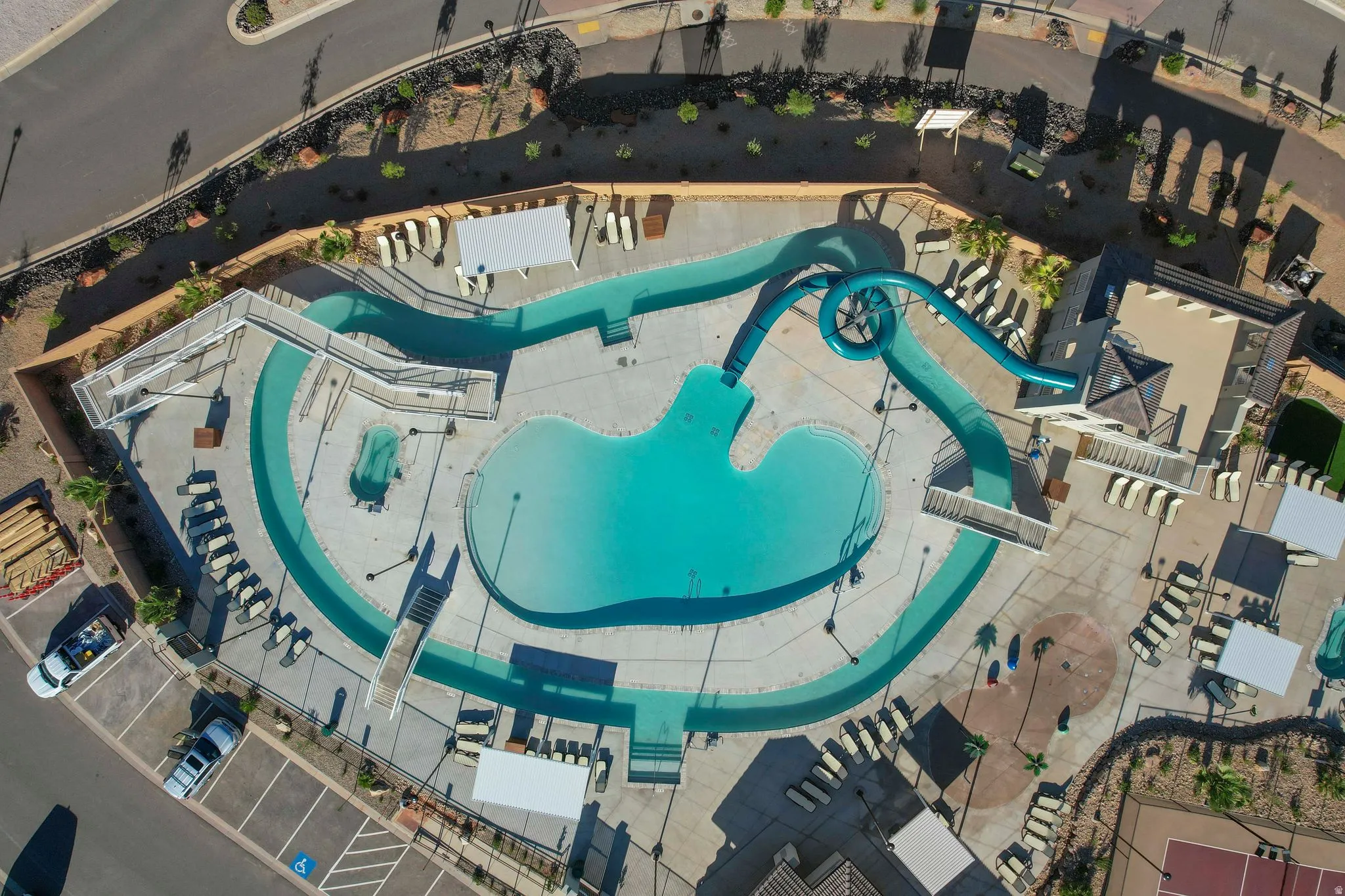 Expansive aquatic area featuring a large swimming pool, a winding lazy river, a multi-story water slide, and an integrated spa