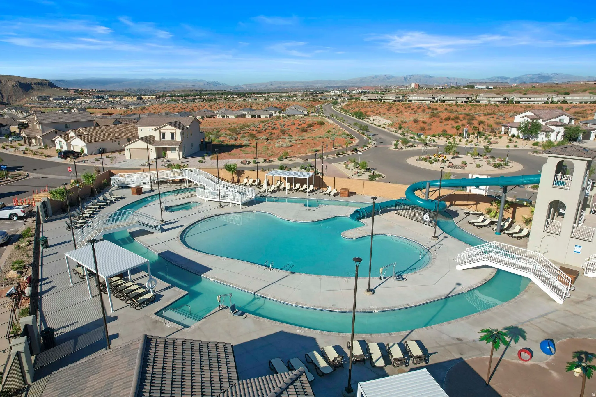 Community aquatic center featuring multiple swimming pools, a lazy river, and a water slide tower
