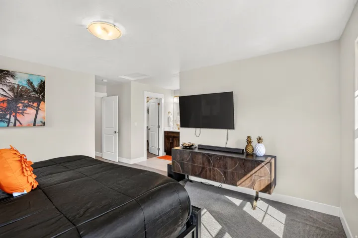 Bright bedroom with neutral wall tones and a ceiling-mounted light fixture