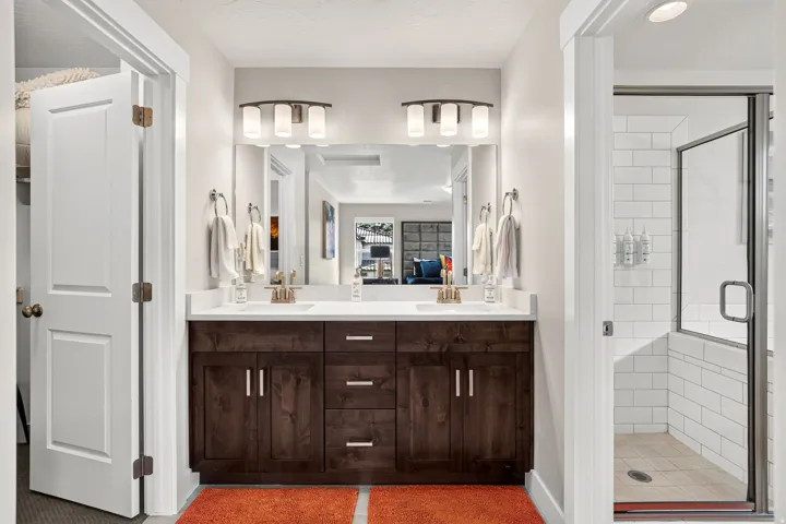 Bathroom featuring a dual vanity with a dark wood-finish cabinet and white countertop