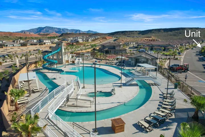 Community pool area featuring a water slide, a lazy river, and multiple lounge chairs