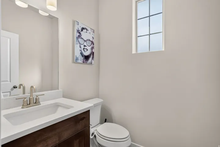 Bathroom vanity with a white countertop and an undermount sink, complemented by a brushed nickel faucet