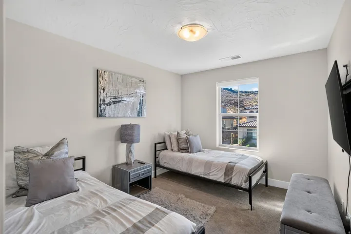 Bright room featuring a prominent window, neutral wall paint, textured ceiling, and flush mount lighting