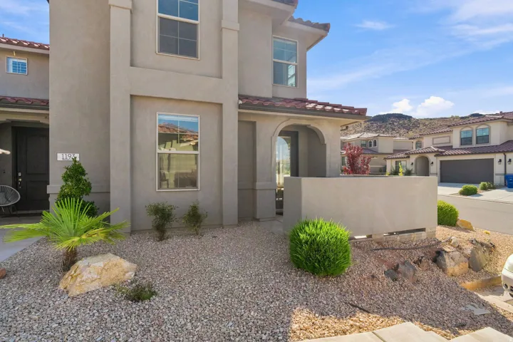 Stucco exterior with a tile roof, featuring a covered entryway with an arched opening