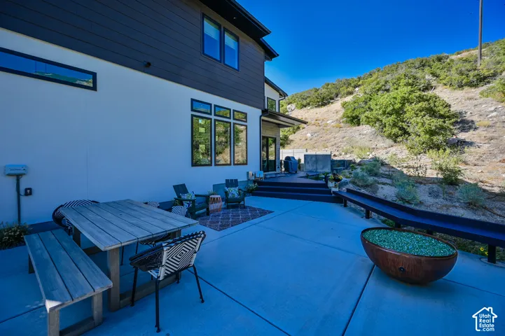 Spacious concrete patio with dark siding and white stucco exterior