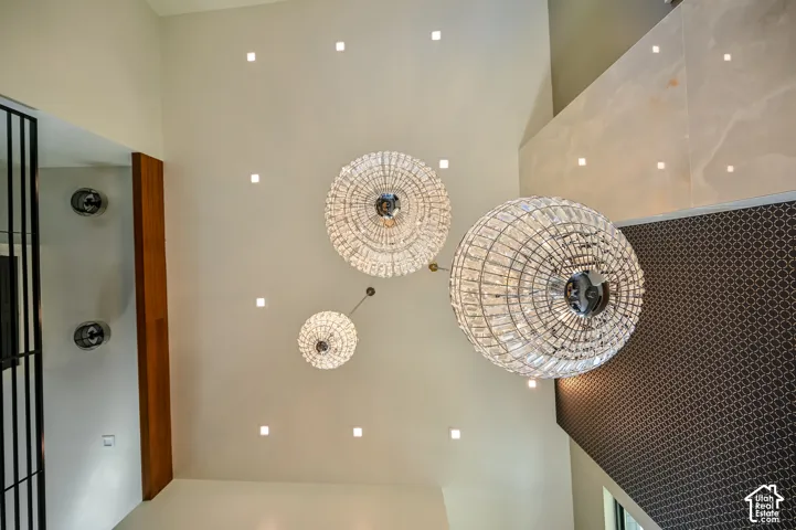 Grand ceiling featuring three crystal chandeliers and recessed lighting