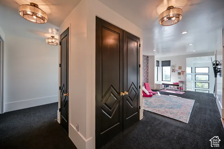 Dark carpeting throughout with white baseboards and walls