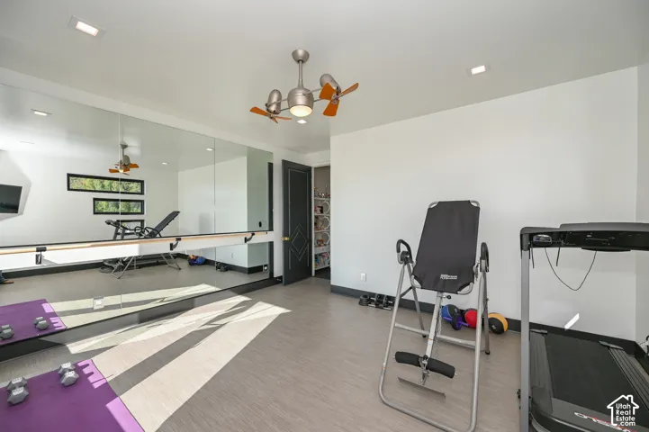 Dedicated fitness room featuring a full wall of mirrors with a ballet barre, recessed lighting, and a ceiling fan