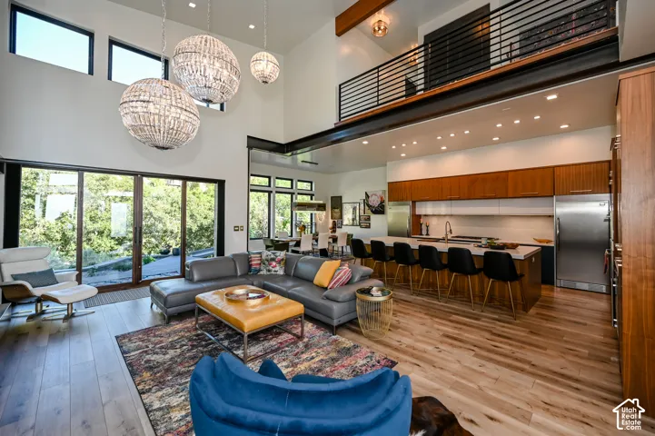 Open-concept living space featuring high ceilings, wood-finish flooring, and large sliding glass doors
