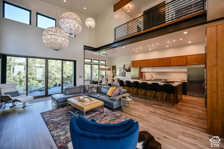 Expansive open-concept living space featuring high ceilings, wood-finish flooring, and large sliding glass doors