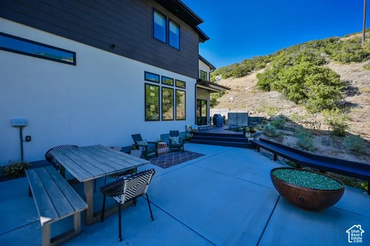 Expansive concrete patio with a tiered deck, large windows, and modern exterior siding