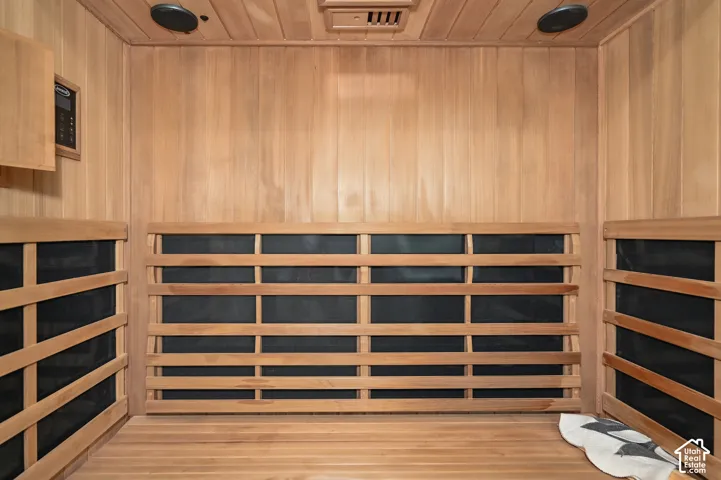 Infrared sauna featuring slat-wood walls and seating, built-in ceiling speakers, and digital controls