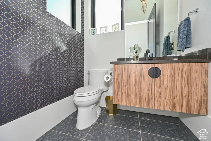 Powder room featuring a floating wood-finish vanity with a dark countertop and matte black faucet