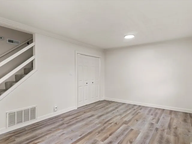 Interior space featuring wood-finish flooring, white walls, and bright overhead lighting
