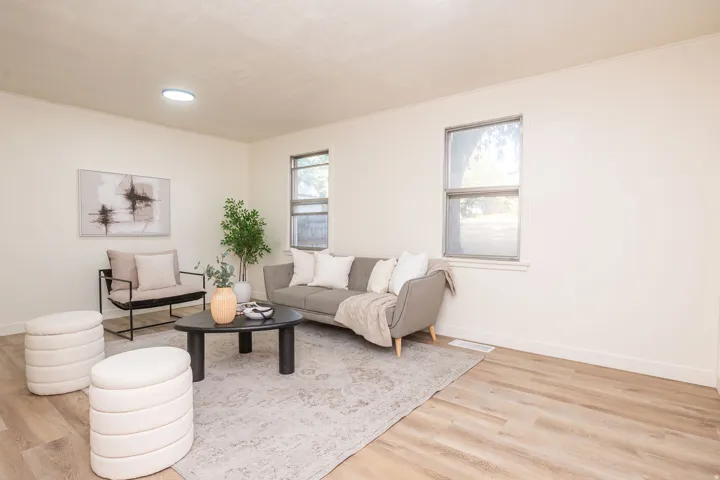 Bright living space featuring light-toned walls and wood-finish flooring