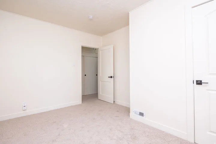 Bright bedroom featuring neutral carpet flooring, white 6-panel closet doors, and recessed ceiling lighting