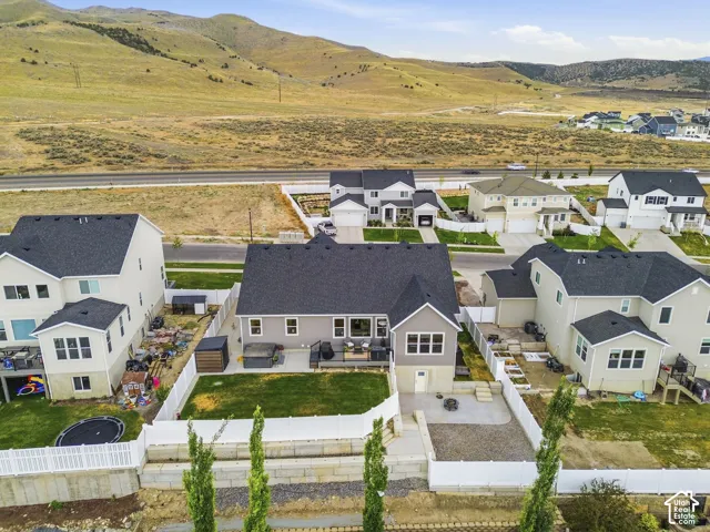 Rear exterior featuring a spacious lawn, extended patio, and privacy fencing