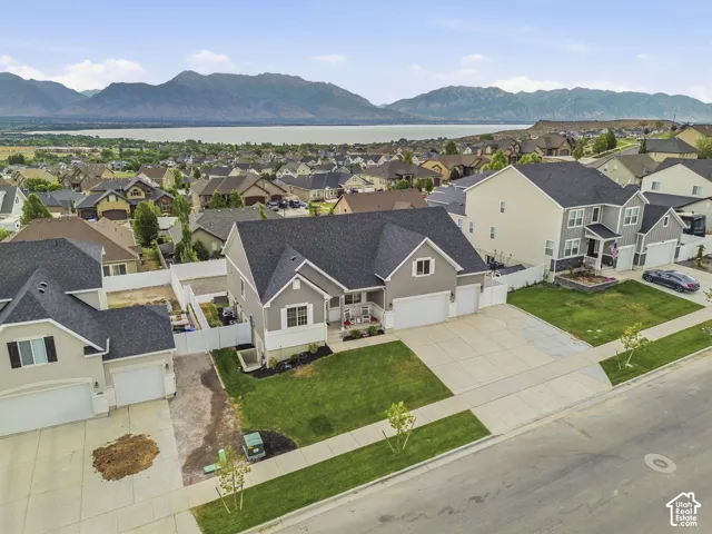 Contemporary residence featuring a two-car garage, concrete driveway, and manicured front lawn