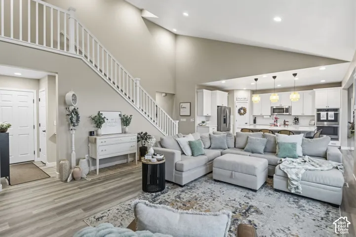 Spacious living area featuring high ceilings, wood-finish flooring, and recessed lighting