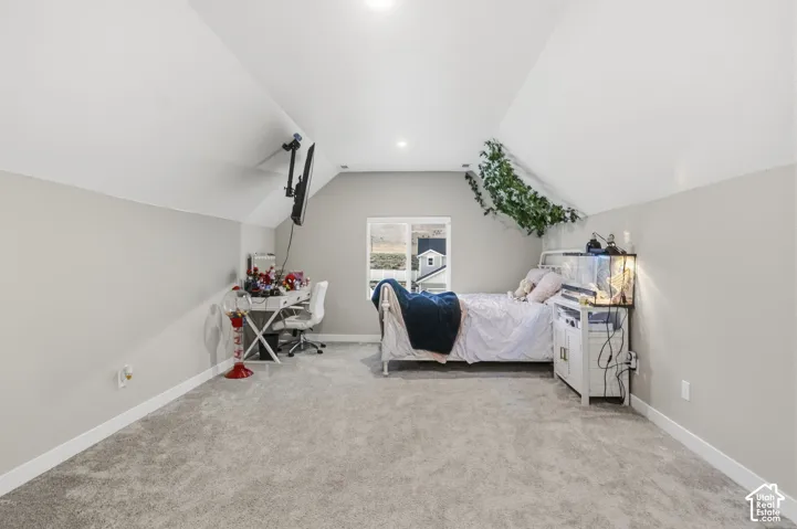 Carpeted room featuring a single window, white baseboards, sloped ceilings, and recessed lighting
