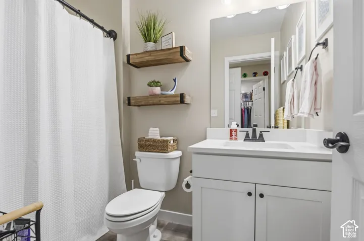 White vanity with a single sink, black faucet, and white countertop