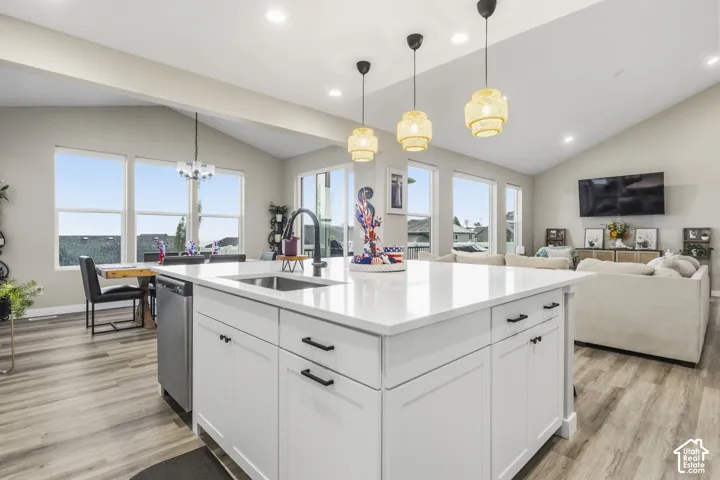 Kitchen island featuring a white countertop, undermount sink, and matte black faucet