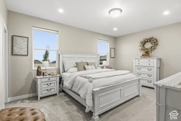 Spacious room featuring neutral-toned walls, two windows, recessed lighting, and a central ceiling fixture