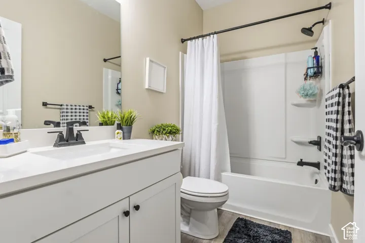Bathroom featuring a white vanity with integrated sink, matte black faucet, and a large wall mirror
