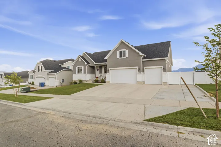 Contemporary gray stucco exterior featuring white trim and a dark shingle roof