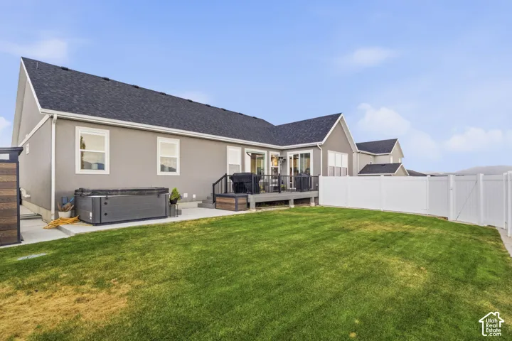 Expansive lawn area with a white privacy fence