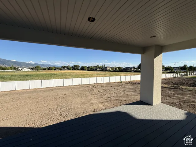 Covered patio with composite decking, stucco column, and a slatted ceiling