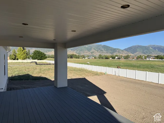 Covered patio featuring a composite deck, recessed lighting, and white vinyl fencing