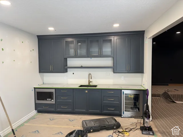 Custom cabinetry with glass-front uppers, an undermount sink, and a built-in microwave