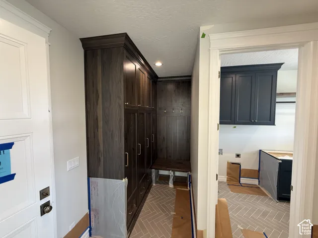 Built-in dark wood-finish cabinetry, integrated bench seating, and wall-mounted coat hooks