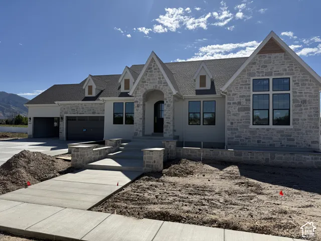 Stone and stucco exterior with multiple gables and a multi-pane window configuration