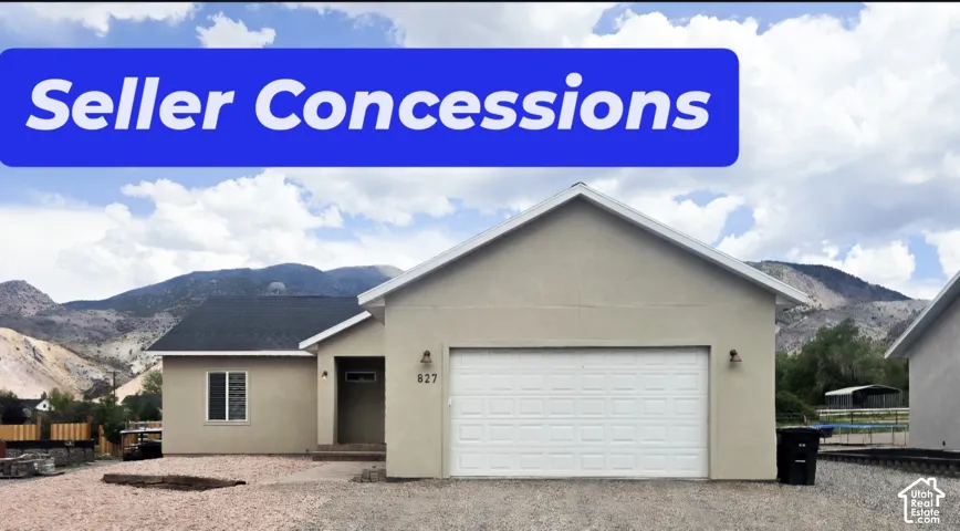 Single-level residence featuring a neutral stucco exterior, a dual-pitch roofline, an attached two-car garage, and mountain scenery