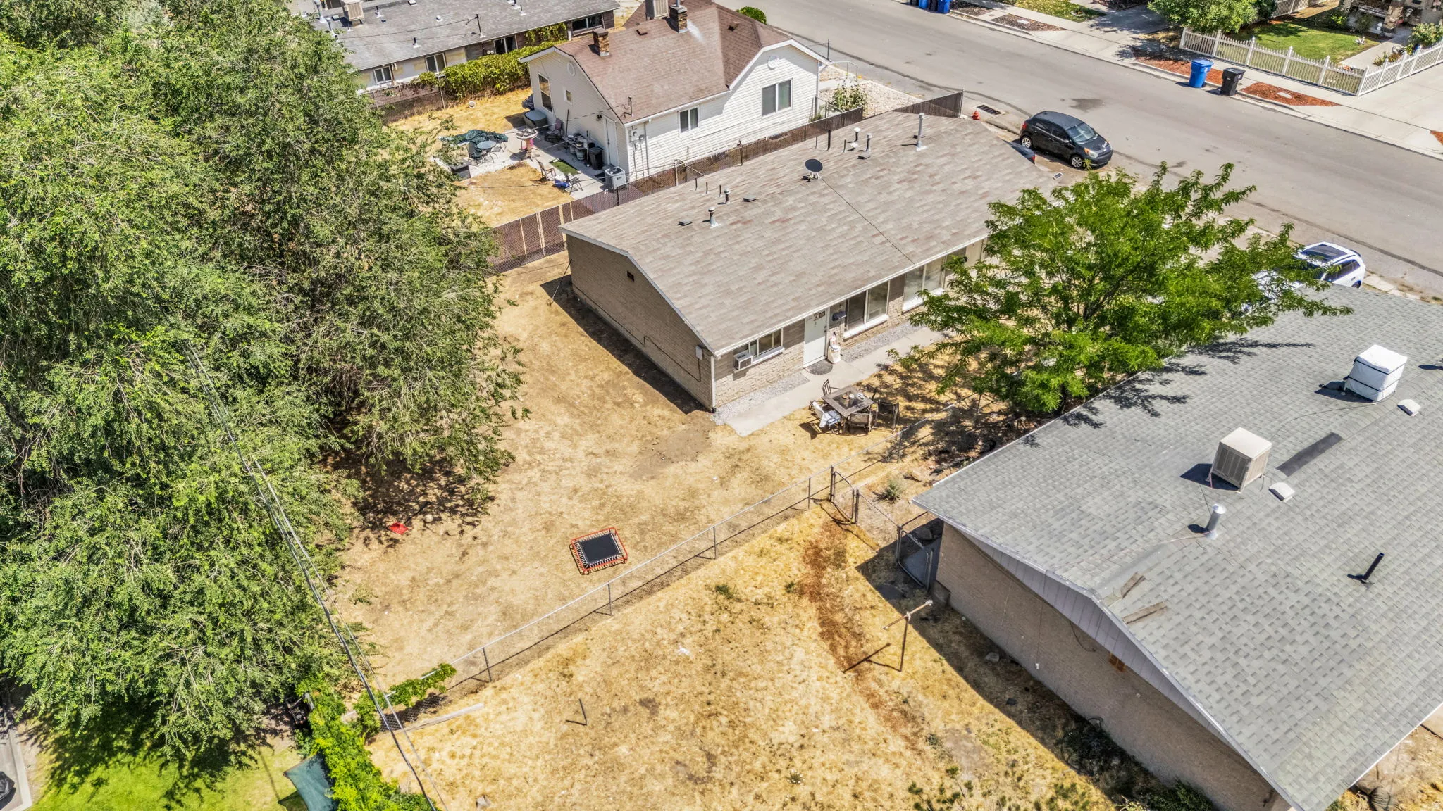 Expansive property grounds featuring a spacious backyard, mature trees, and fencing