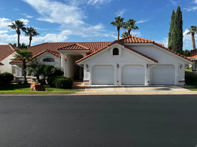 Mediterranean-style exterior featuring a red tile roof and white stucco finish