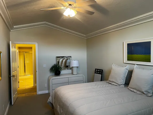 Vaulted ceiling with crown molding and ceiling fan