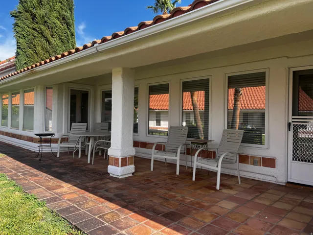 Covered patio featuring an expansive terracotta tile floor and textured stucco columns