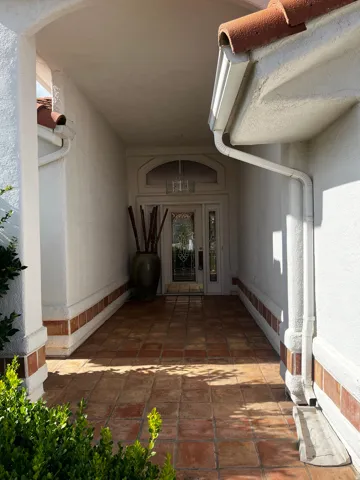 Inviting covered entryway featuring terracotta tile flooring