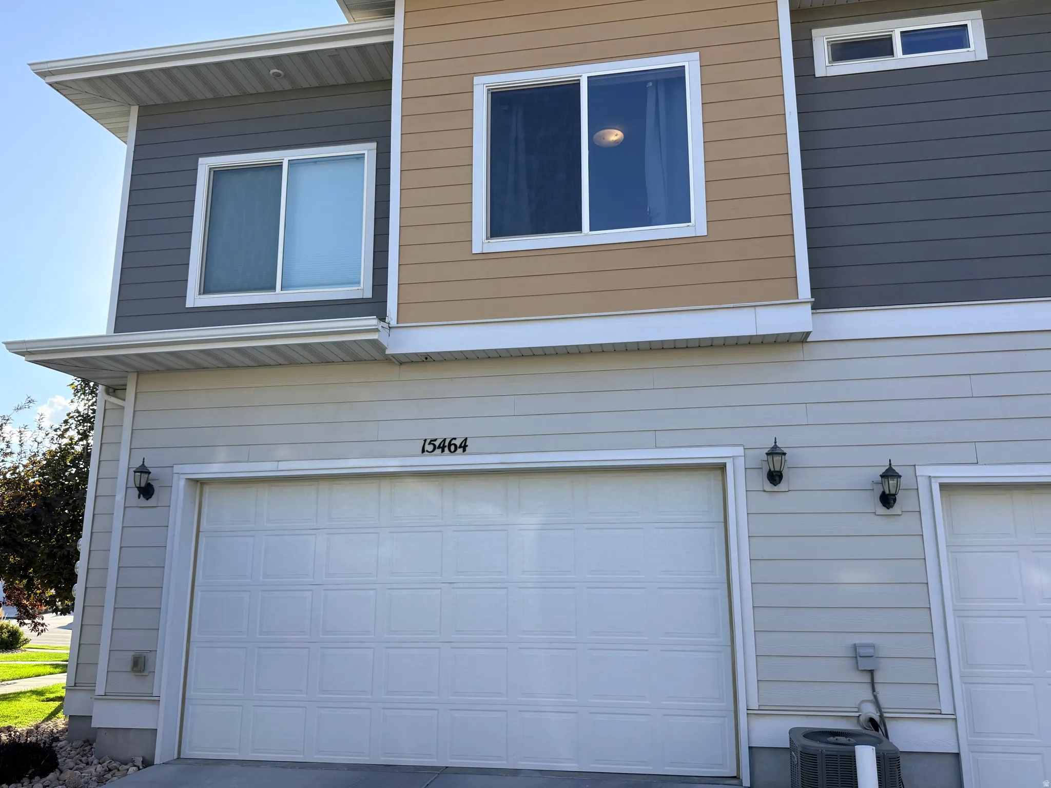 Contemporary exterior with multi-toned siding, featuring a prominent two-car garage