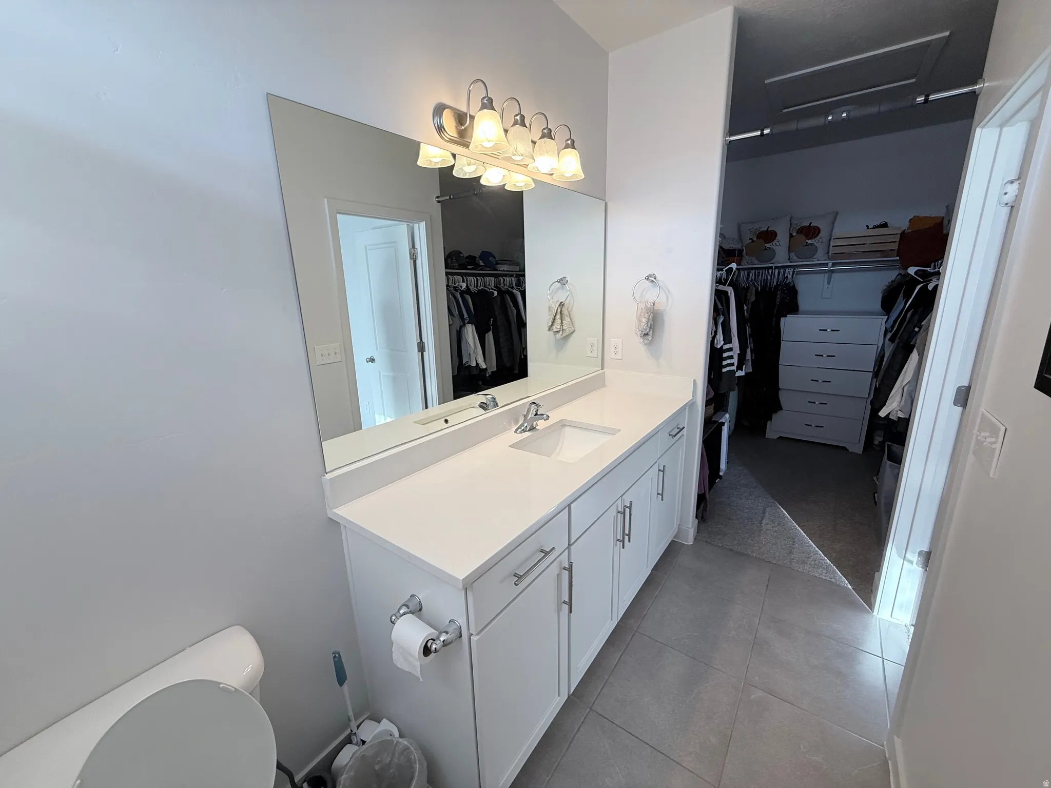 Contemporary vanity featuring a single integrated sink, stone-finish countertop, and ample storage cabinetry
