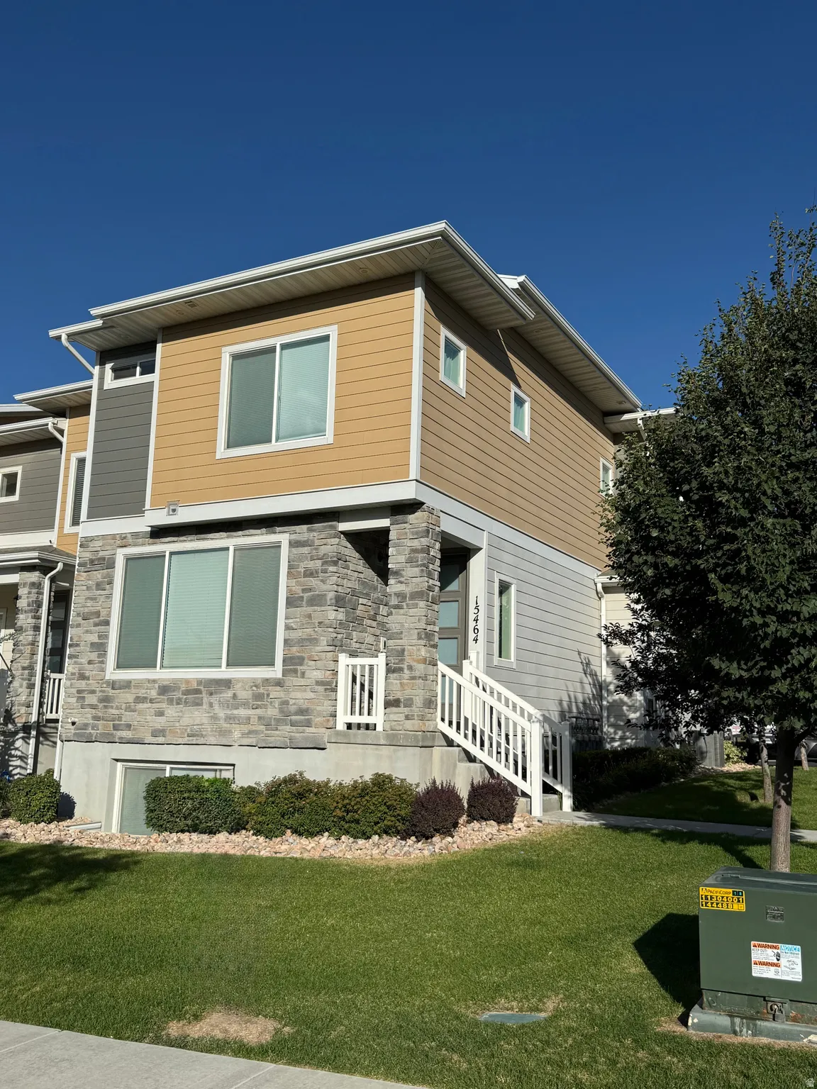 Modern multi-story residence featuring a combination of stone veneer and horizontal siding