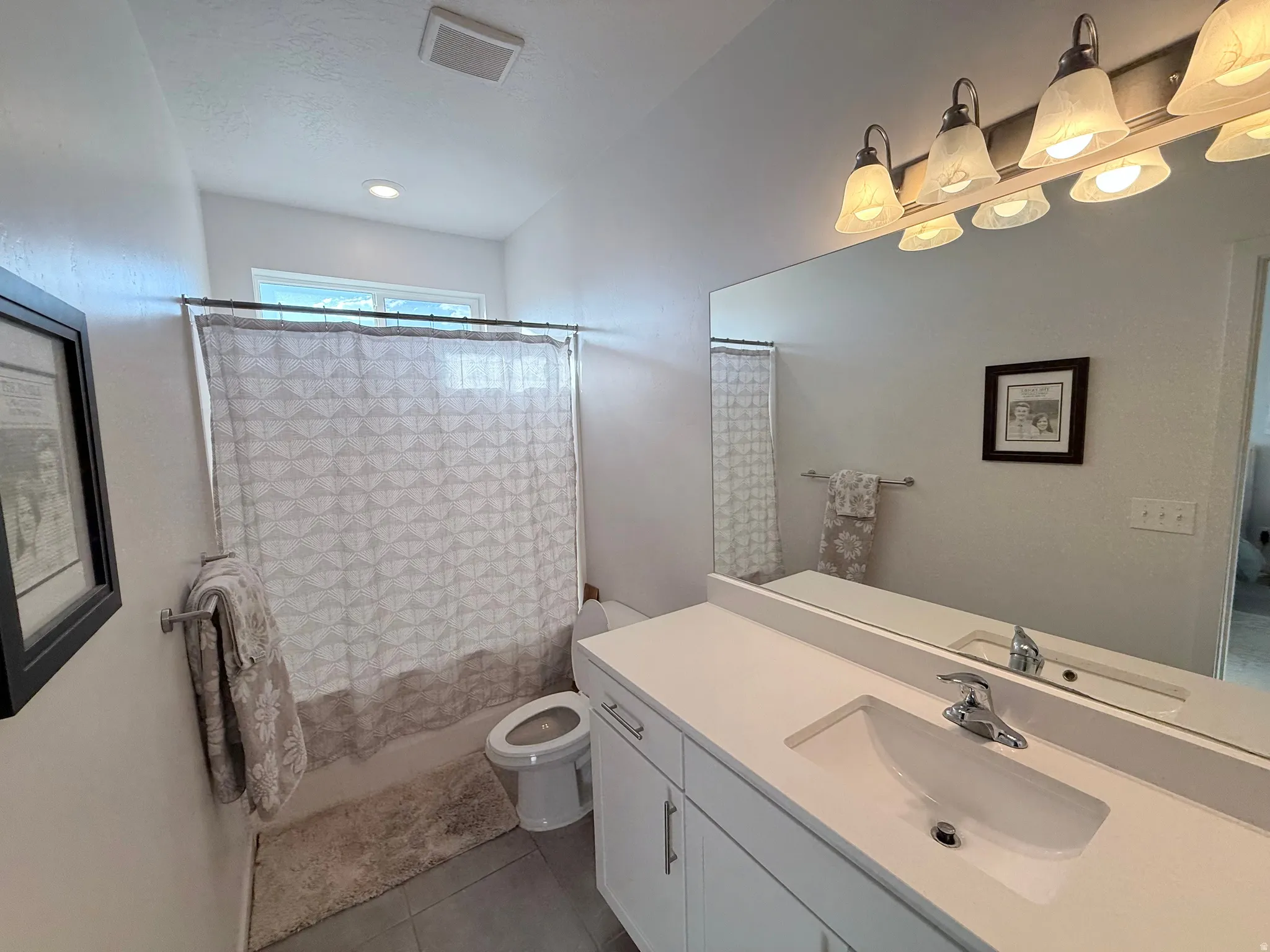 Bathroom featuring a large vanity with an integrated rectangular sink and polished chrome faucet